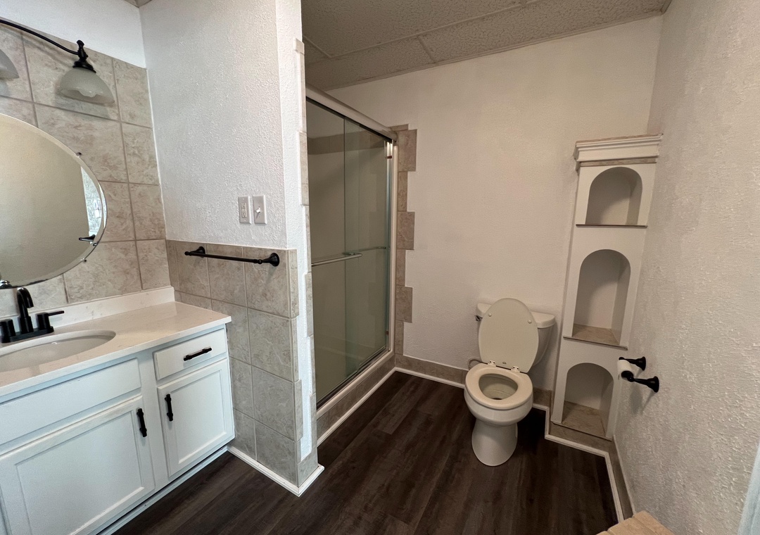 Refresh in your private bathroom featuring a spacious walk-in shower, modern vanity, and convenient built-in storage niches.