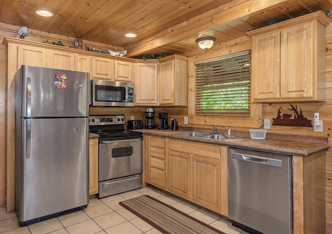 Your fully-equipped kitchen features stainless steel appliances and warm wood cabinetry, perfect for preparing meals during your mountain getaway.