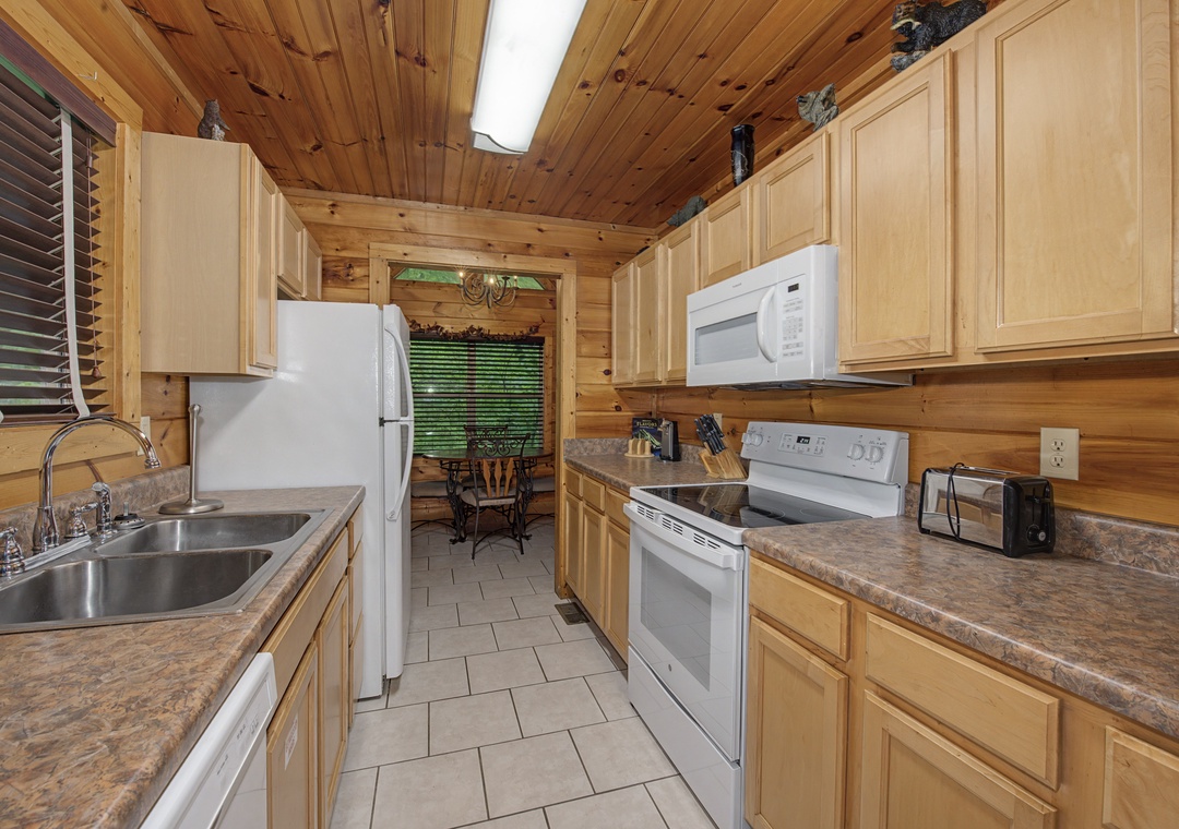 Your fully equipped kitchen awaits with stainless steel appliances, ample counter space, and warm wood finishes—perfect for preparing family meals and morning coffee in your mountain getaway.