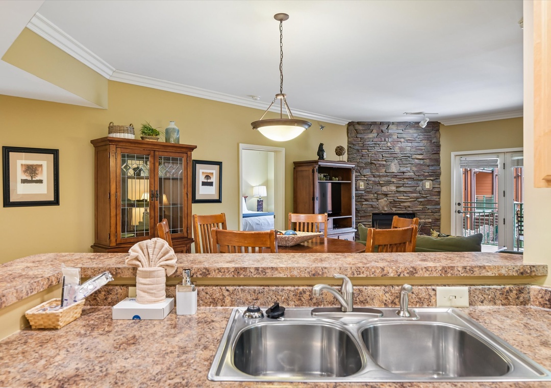 Your open-concept kitchen flows beautifully into the dining and living areas, featuring granite counters and cozy stone fireplace for memorable gatherings.