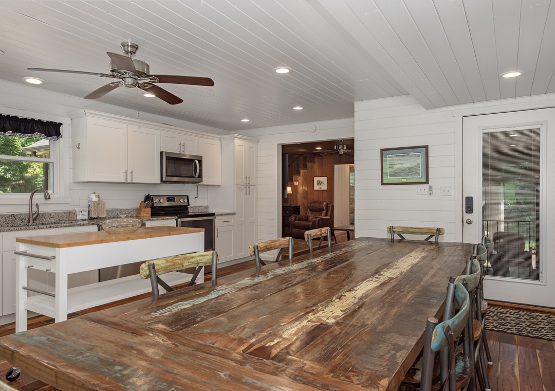 Gather around this stunning reclaimed wood table where your group can share meals and make memories in a bright, breezy space with vaulted ceilings and natural light streaming in.