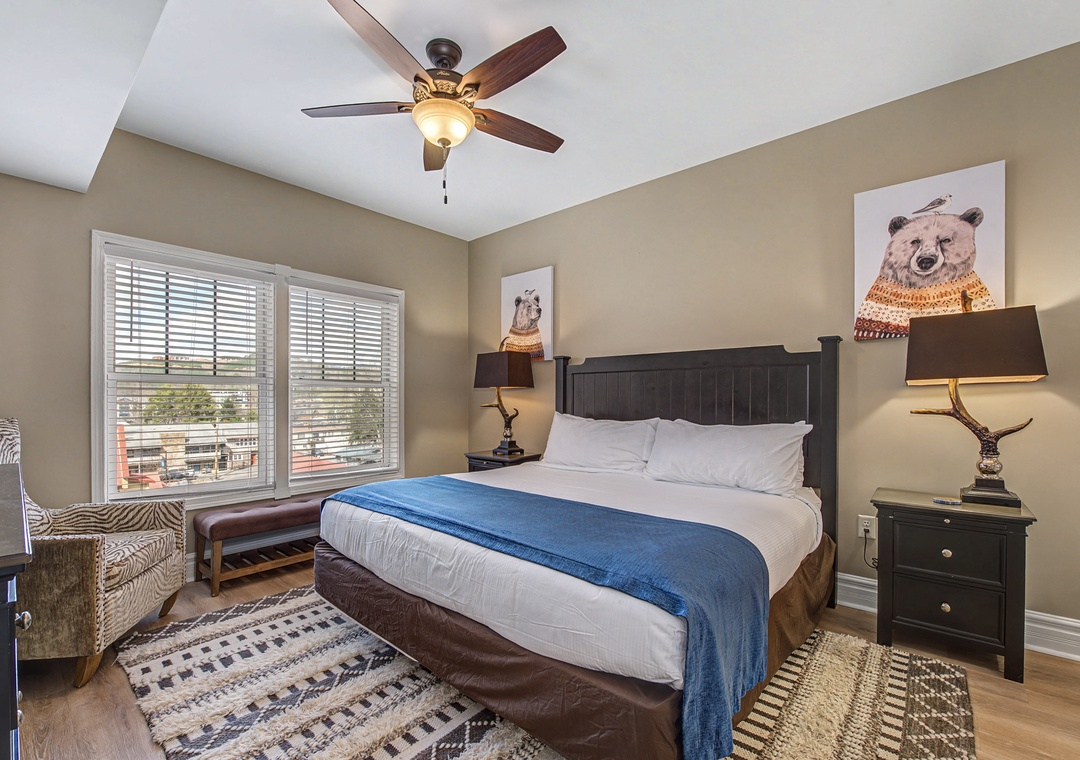 Drift off in your cozy bedroom with charming bear artwork, crisp linens, and gentle ceiling fan breeze creating the perfect retreat.