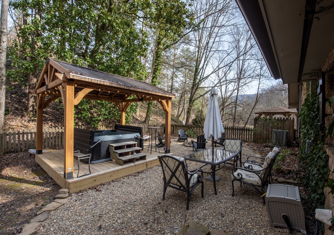 Unwind in your private hot tub under the covered pavilion, then gather around the glass dining table for memorable meals in this serene backyard retreat.