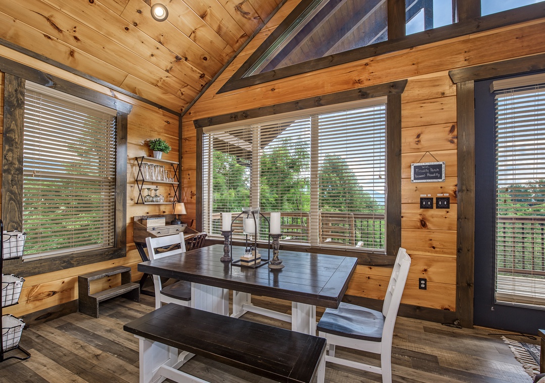Picture yourself gathering around this farmhouse table in a warm, wood-lined cabin, where expansive windows frame lush forest views and vaulted ceilings add rustic charm.