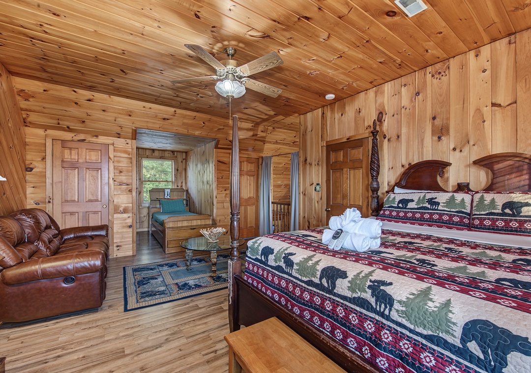 Unwind in your cozy cabin bedroom, where rustic wood tones and charming wildlife-themed bedding create a warm mountain retreat. Sink into the plush leather chair after a day of adventure.