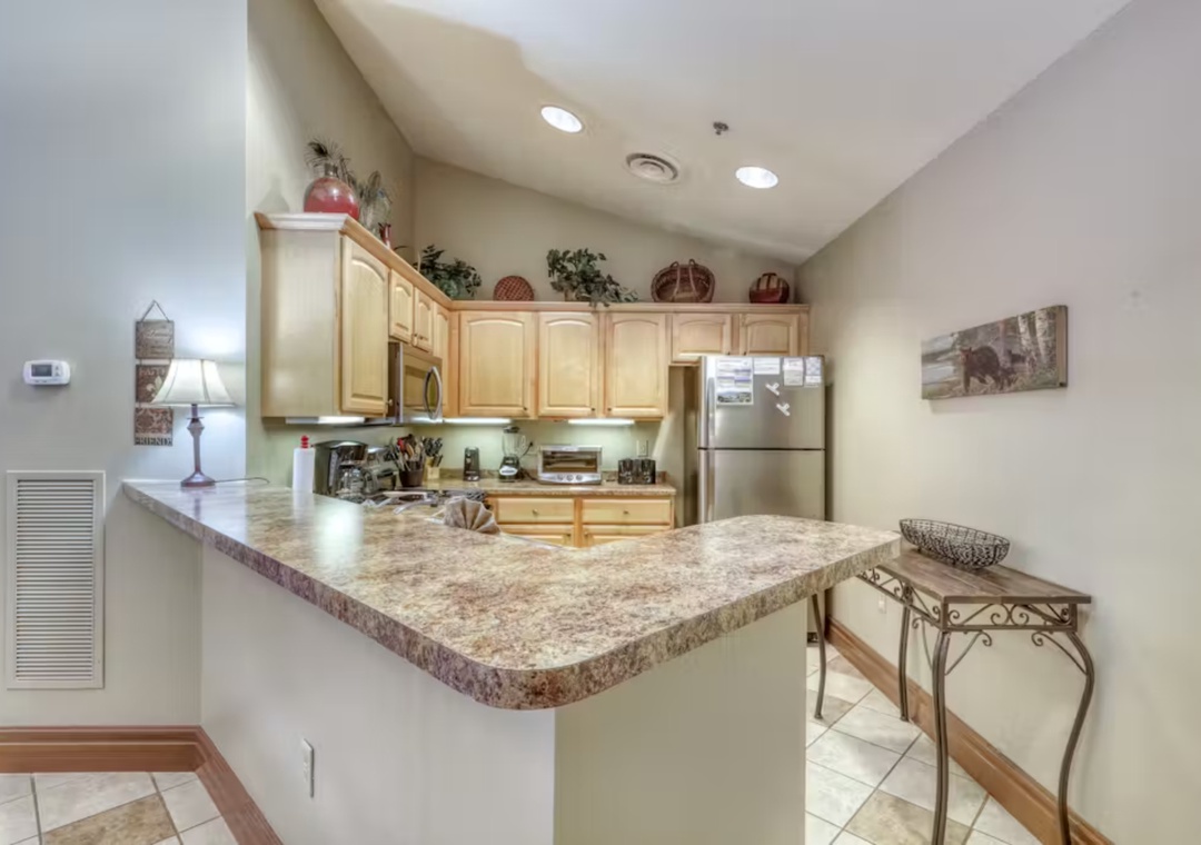 Your fully equipped kitchen features granite counters, stainless steel appliances, and breakfast bar for cooking delicious meals during your stay.