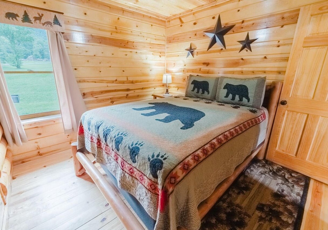 Your cozy retreat features handcrafted pine walls, rustic bear-themed bedding, and charming star accents. Wake up to peaceful green views from your private window.