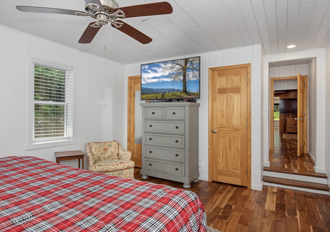 Your cozy bedroom features warm wood floors, a ceiling fan for comfort, and charming cottage-style details that make it feel like a peaceful retreat.