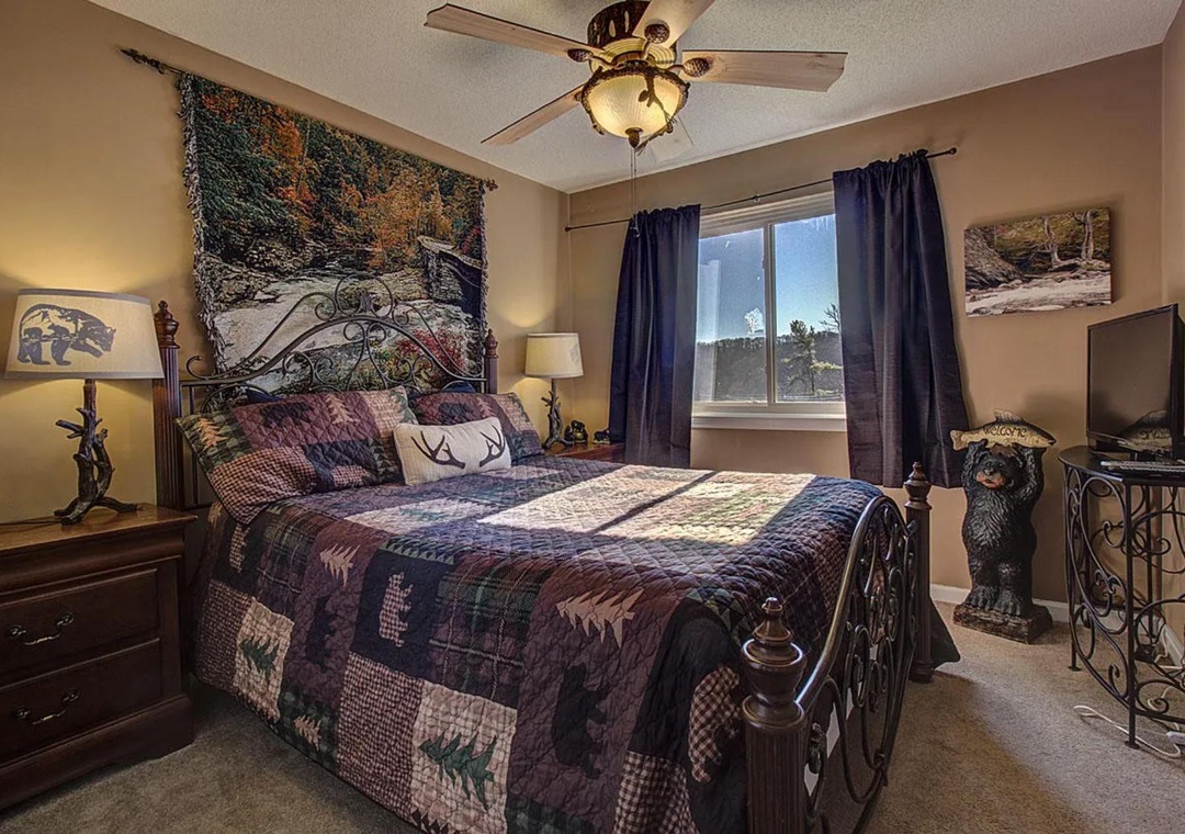 Cozy up in your rustic-themed bedroom featuring wildlife décor, plush quilted bedding, and peaceful natural light streaming through your window.