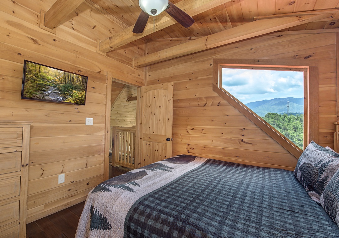 Drift off to sleep in this cozy bedroom with warm wood accents, where your unique angled window frames breathtaking mountain views that greet you each morning.