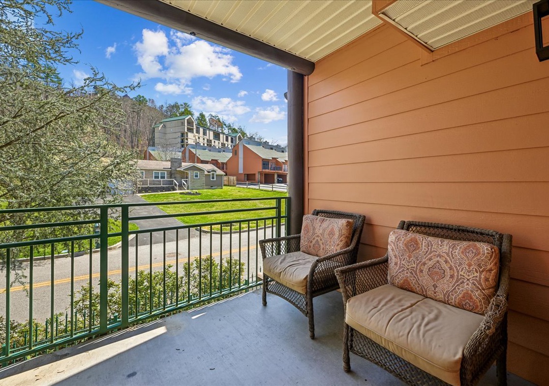 Step onto your private balcony with wicker seating where you'll enjoy peaceful neighborhood views beneath the covered terrace.