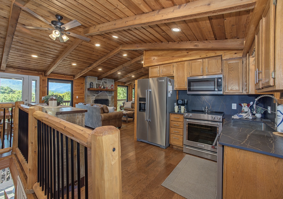 Warm wood beams and vaulted ceilings open your mountain escape to sweeping natural views. Your full kitchen awaits with modern appliances, while the cozy living area invites you to unwind by the fireplace after a day of adventure.