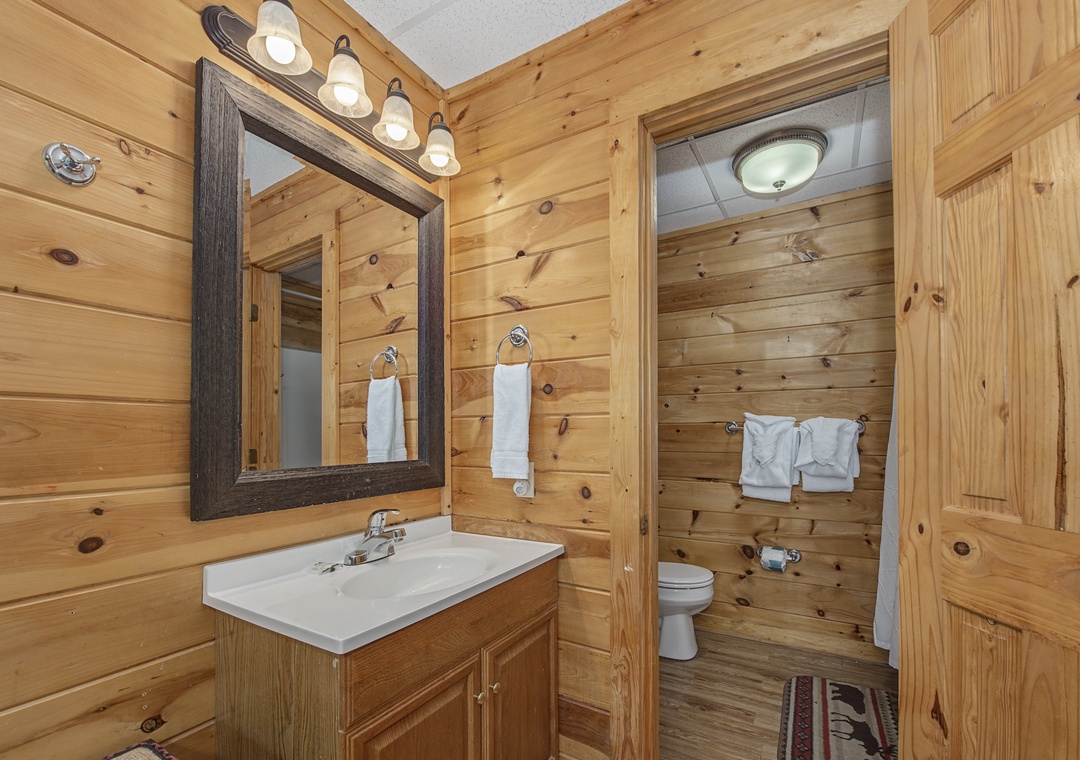 Step into your rustic retreat bathroom featuring warm wood walls and fresh white towels waiting for you.