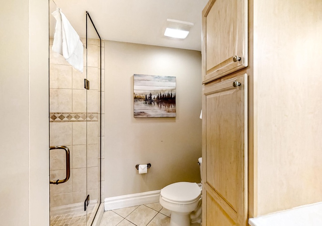 Unwind in your private bathroom featuring a spacious glass shower, thoughtful storage, and warm wood finishes that create a spa-like retreat.
