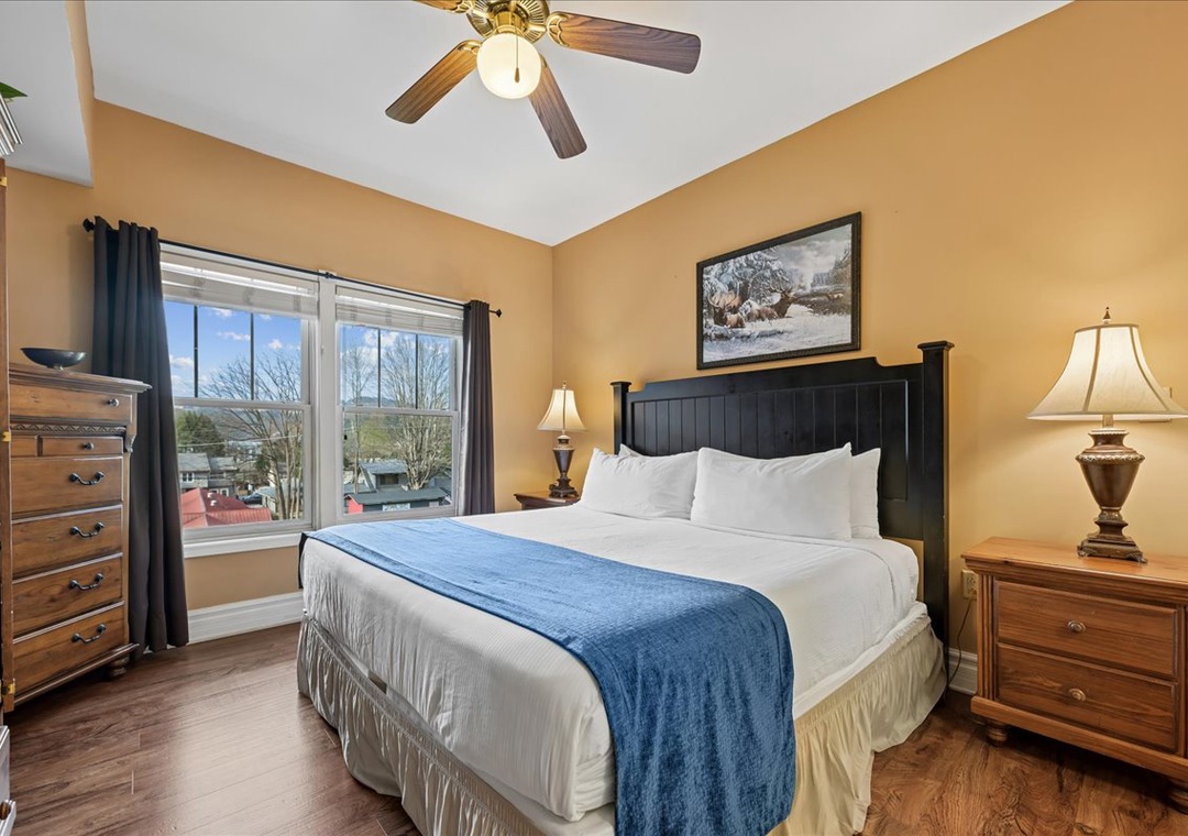 Sink into crisp linens and enjoy gentle breezes from your ceiling fan in this cozy bedroom retreat.