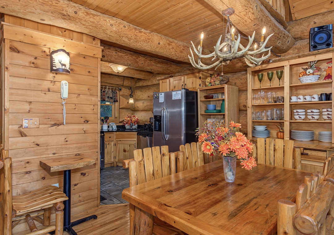 Gather around the handcrafted log table under a striking antler chandelier. Your fully-equipped kitchen awaits with stainless appliances and open shelving for easy access to everything you need.
