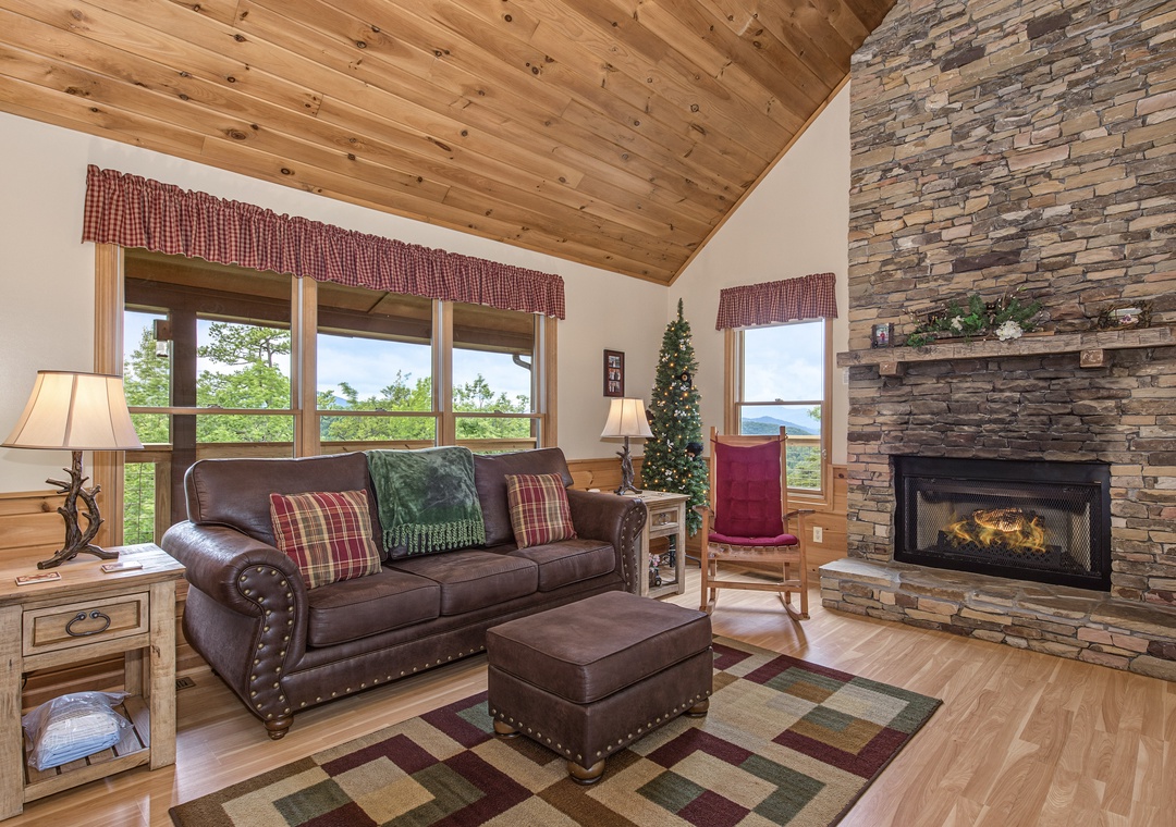 Unwind in your bright living room with vaulted wood ceilings, a cozy stone fireplace, and scenic mountain views through large windows.
