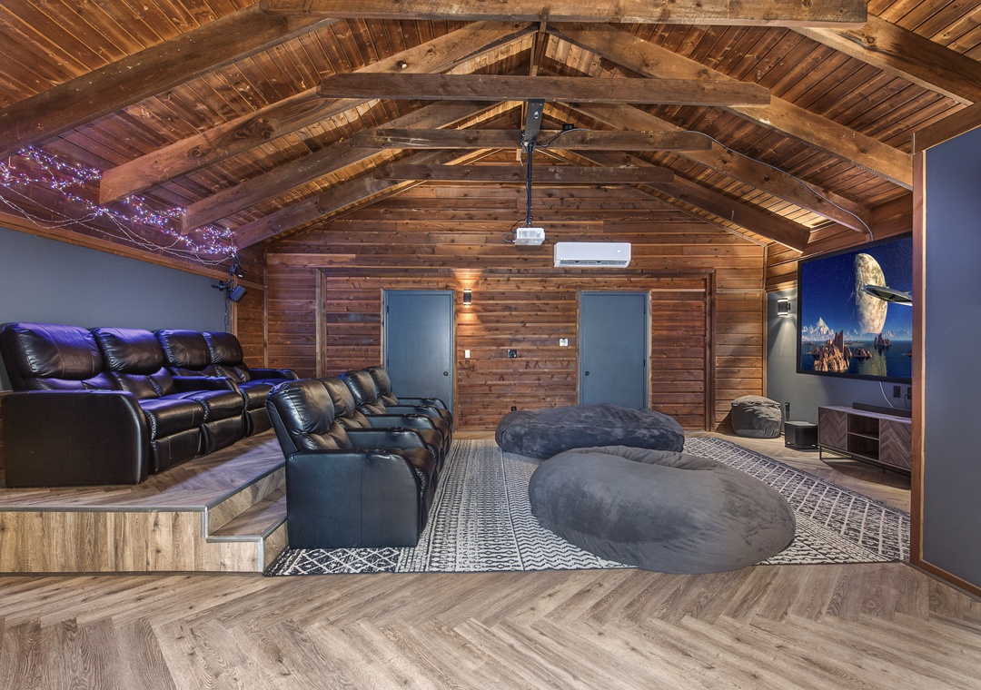 Sink into plush recliners or oversized bean bags under dramatic vaulted wood ceilings—your private retreat for movie nights and total relaxation.