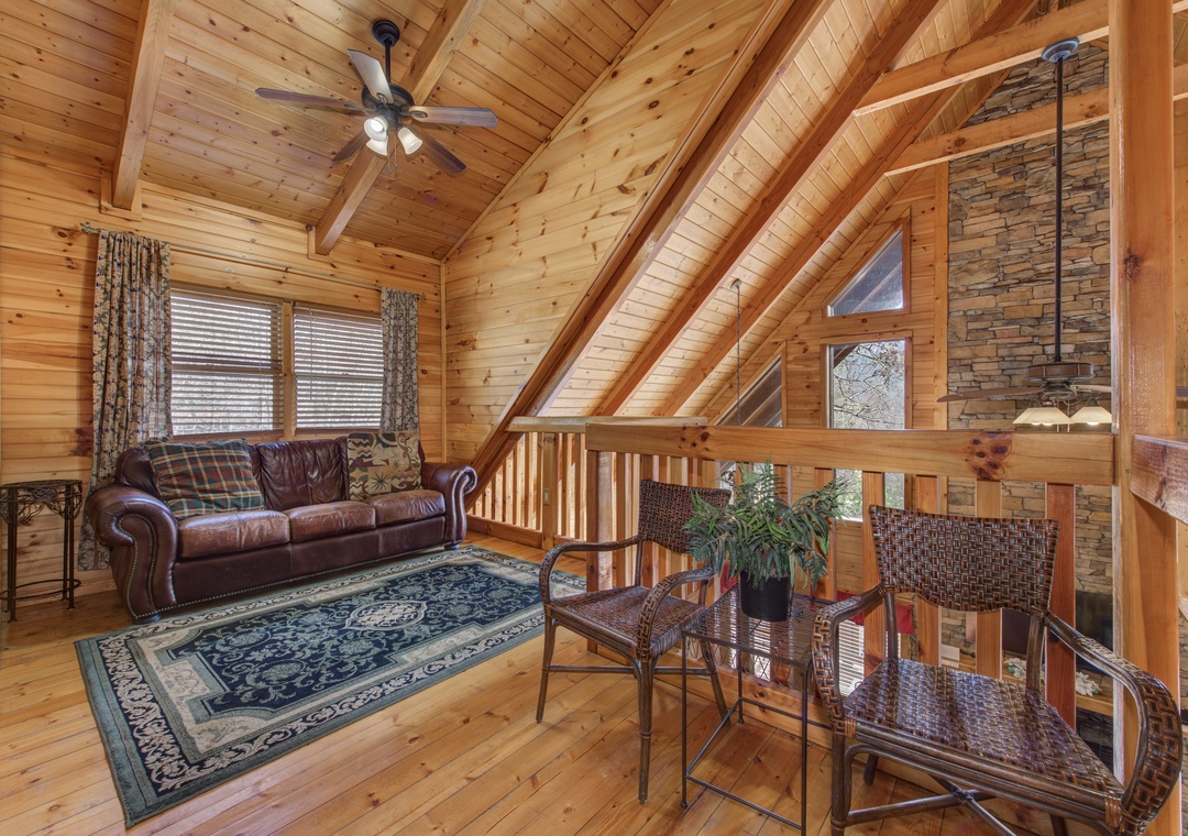 Unwind in this cozy loft featuring exposed beams, leather seating, and warm wood throughout your mountain retreat.