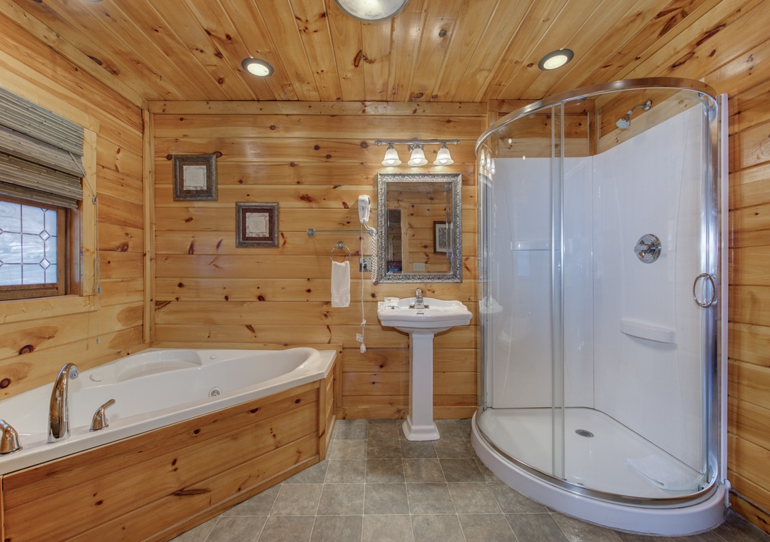 Unwind in your rustic cabin bathroom featuring a jetted tub and curved glass shower surrounded by warm knotty pine walls.