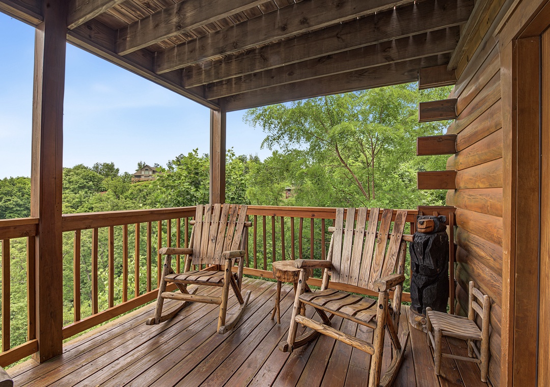 Settle into your handcrafted rocking chairs on this covered porch and soak in sweeping forest views. Perfect for morning coffee or evening relaxation in pure mountain tranquility.