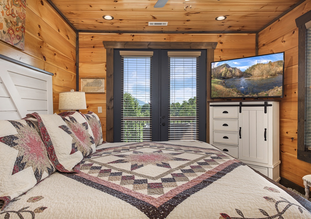 Wake up to stunning mountain views in this cozy cabin bedroom. Handcrafted quilts and warm wood tones create your perfect retreat after days exploring the Smokies.