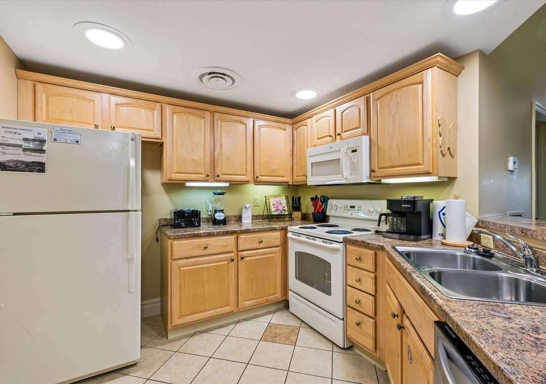 Your fully equipped kitchen awaits with everything needed for home-cooked meals. Granite counters, full appliances, and warm wood cabinets create a comfortable cooking space.