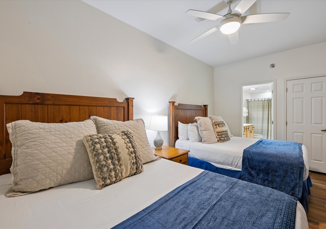 Rest peacefully in your twin-bed sanctuary with rich wood headboards, soft quilted linens, and a gentle ceiling fan for perfect comfort.