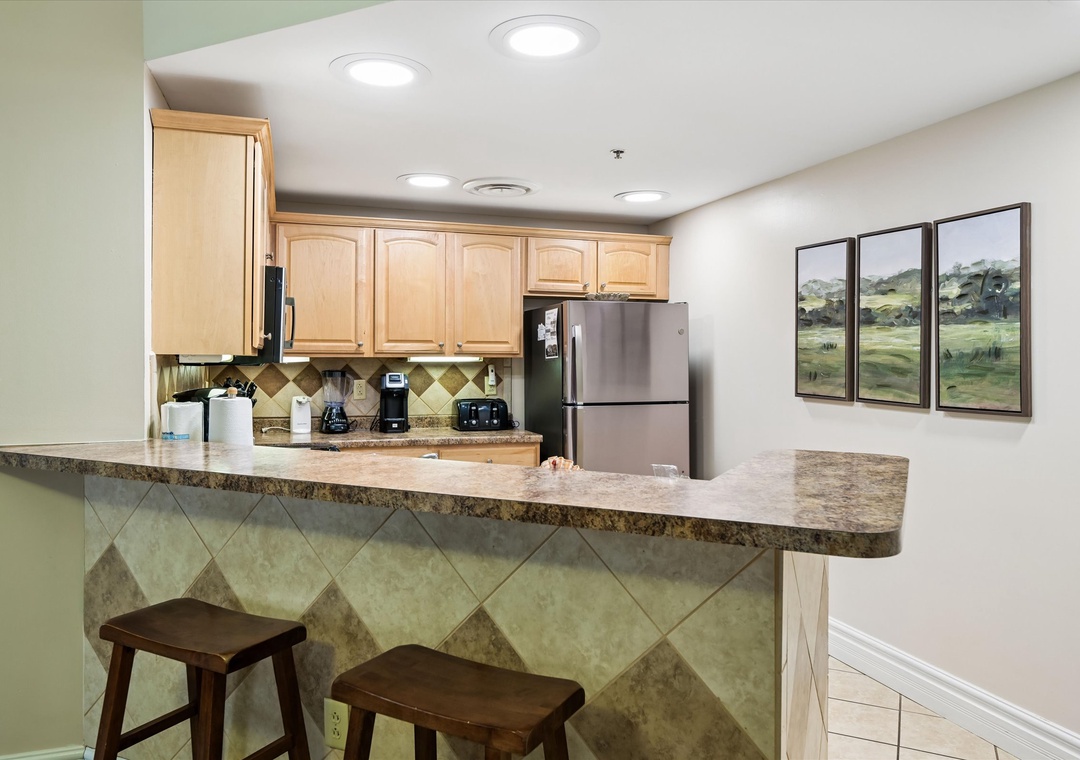 Your fully equipped kitchen features granite counters, stainless appliances, and breakfast bar seating—perfect for preparing meals and casual dining together.