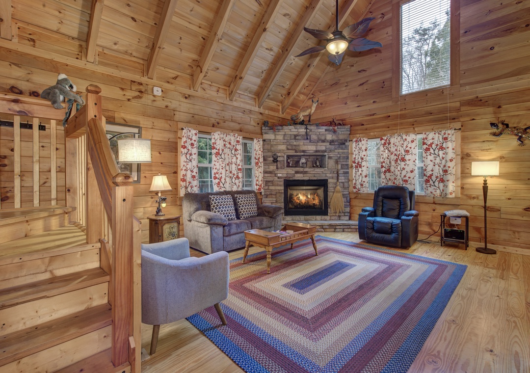 Cozy up in this rustic living room with crackling fireplace and comfortable seating perfect for your mountain getaway.