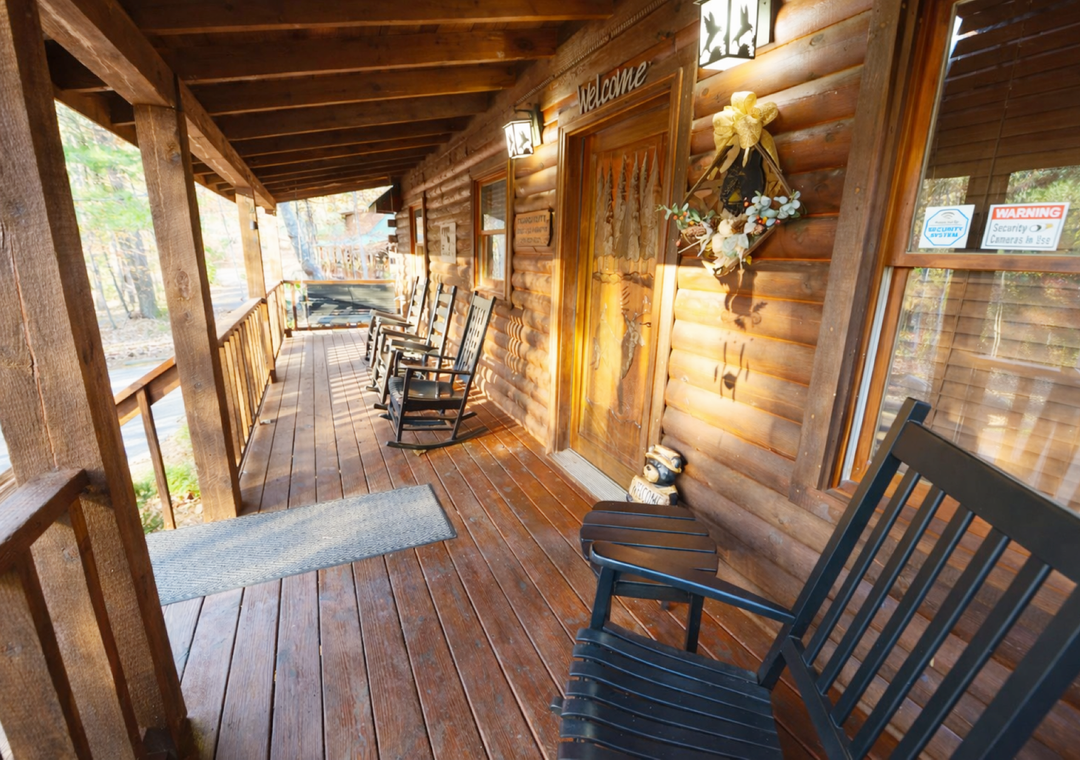 Your private covered porch beckons with rocking chairs and rustic charm, perfect for morning coffee or evening relaxation.