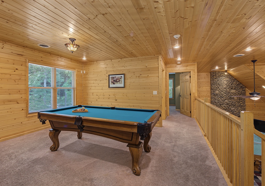 Challenge your friends to a game in this spacious room featuring a professional billiard table, warm wood finishes, and excellent lighting for the perfect shot.