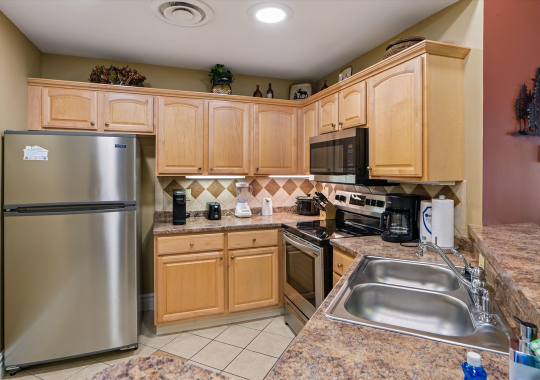 Your fully equipped kitchen features granite countertops, stainless steel appliances, and warm wood cabinets—perfect for preparing memorable vacation meals together.