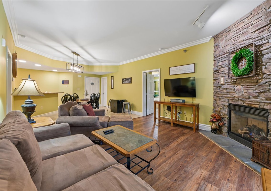 Unwind in your spacious living room with cozy sectional seating, warm fireplace, and entertainment center—perfect for relaxing evenings together.