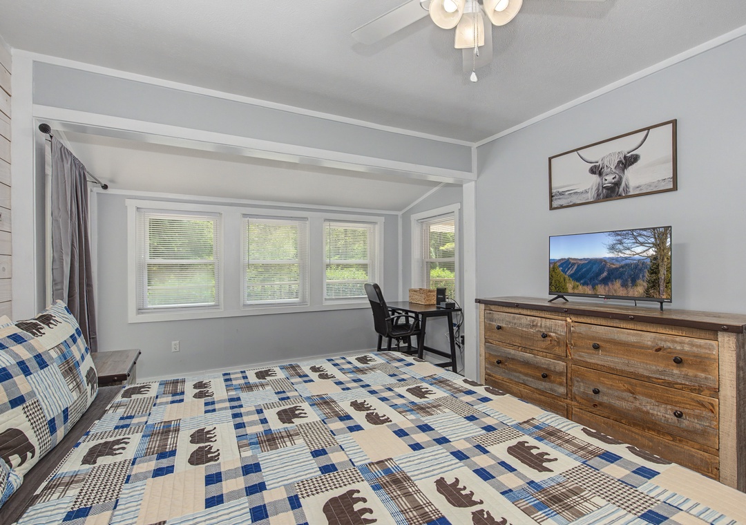 Relax in your rustic bedroom with mountain views streaming through windows, plus a TV for quiet evenings.