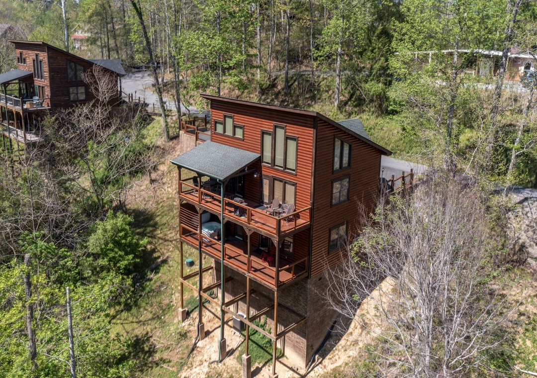 Modern cedar cabin nestled among towering trees, offering a perfect woodland retreat with multiple levels and spacious decks.