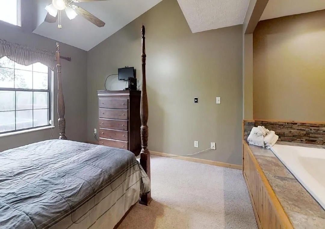 Unwind in your spacious bedroom suite with vaulted ceilings, a luxurious four-poster bed, and a relaxing soaking tub just steps away—perfect for cozy mountain evenings.