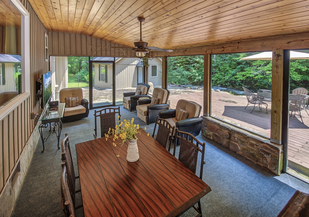 Your screened-in retreat with warm wood ceilings and cozy seating opens to a private deck—perfect for sipping morning coffee or gathering for evening relaxation surrounded by nature.