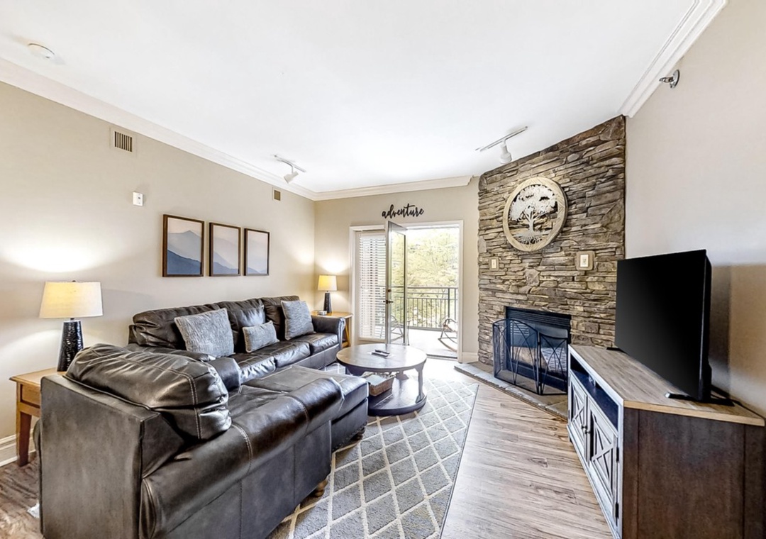 Sink into plush leather seating by your cozy stone fireplace, where rustic charm meets modern comfort in this thoughtfully appointed living space.