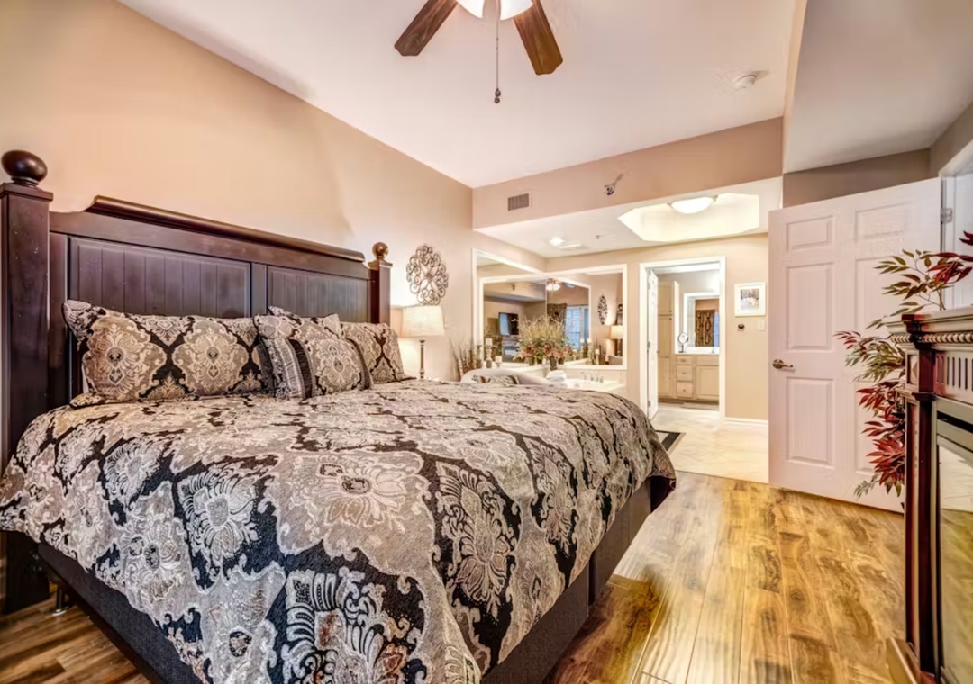 Unwind in your elegant bedroom featuring a plush king bed and warm wood floors that flow seamlessly into the spacious living areas beyond.