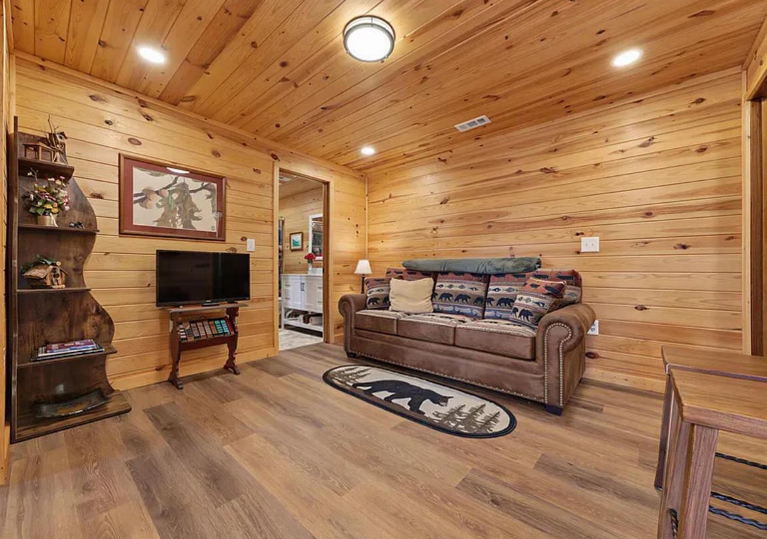 Unwind in your cozy living area with rustic wood walls and comfortable seating perfect for relaxing after a day exploring the outdoors.