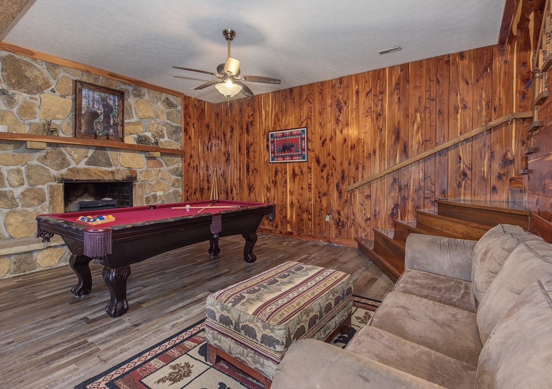 Challenge your friends to a game of pool in this rustic game room, complete with a cozy fireplace and comfortable seating for everyone to enjoy together.