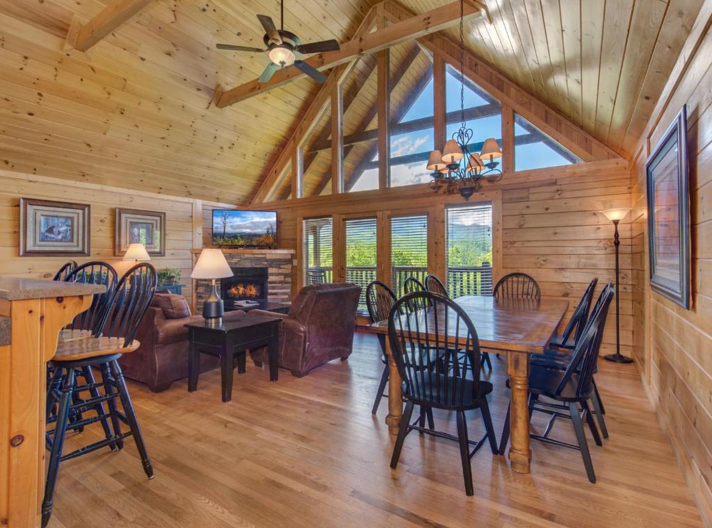 Unwind in your cozy log cabin retreat with cathedral ceilings, crackling fireplace, and mountain views through floor-to-ceiling windows.