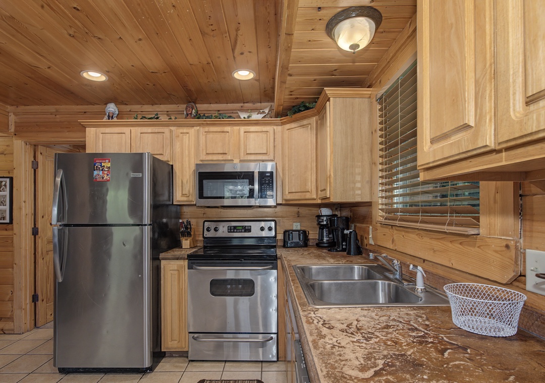 Your fully equipped kitchen features stainless steel appliances and warm wood cabinetry, perfect for preparing family meals during your mountain getaway.