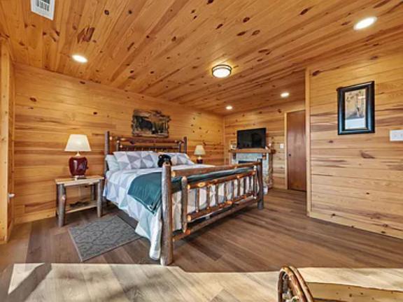 Sink into your rustic log bed beneath warm wood ceilings. Enjoy flat-screen TV, bedside lamps, and authentic mountain lodge character in this restful retreat.