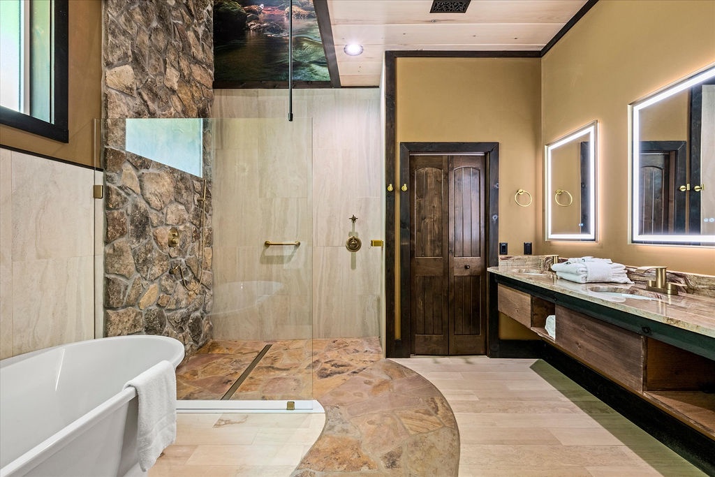 Soak in the freestanding tub or rinse off in the spacious walk-in shower, surrounded by natural stone and warm lighting. Plush towels and double vanities await your morning routine.