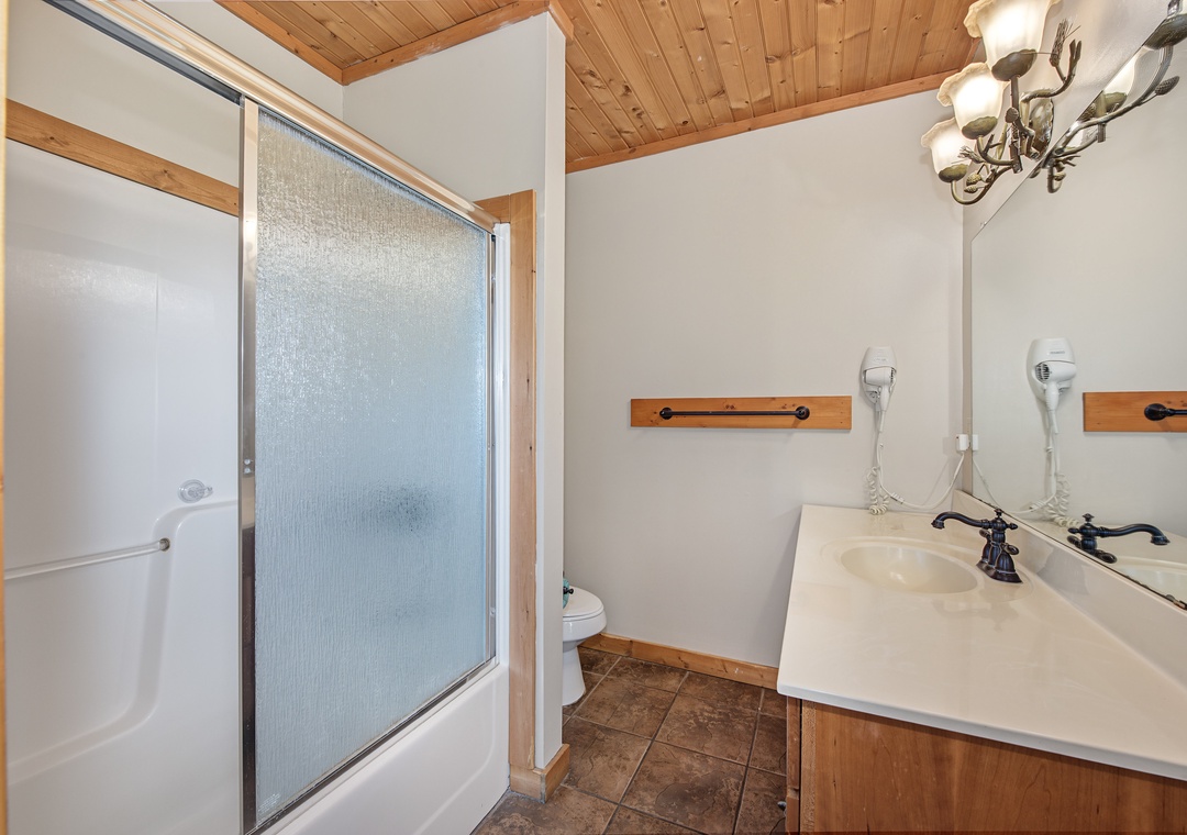 Freshen up in your private bathroom featuring a walk-in shower, wooden accents, and plenty of natural light to start your day right.