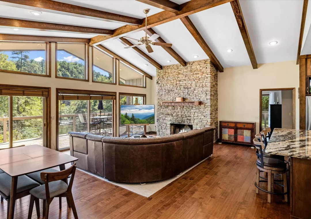 Unwind in your spacious open-concept retreat with stunning mountain views and a cozy stone fireplace perfect for evening relaxation.