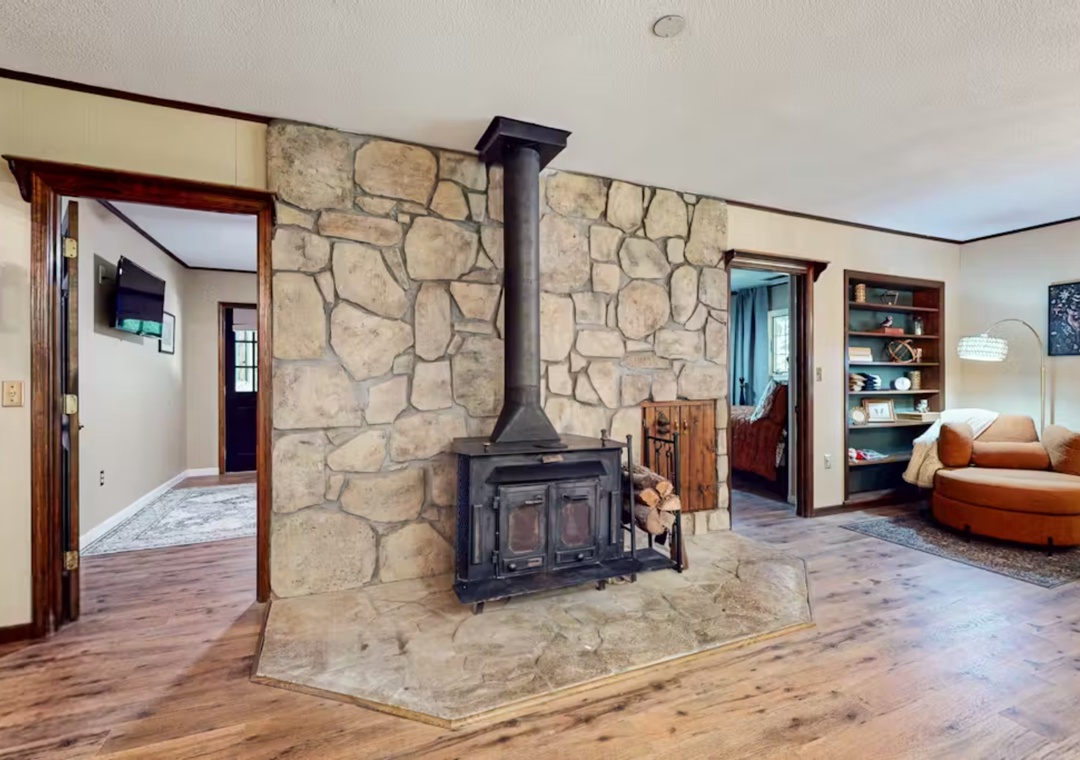 Cozy up by your rustic stone fireplace with warm wood accents throughout this inviting living space.