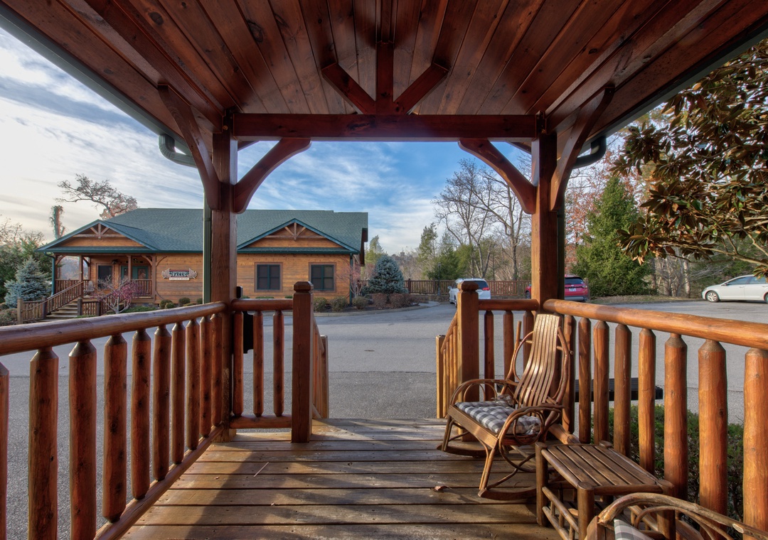 Your private covered porch offers rustic charm with a wooden rocking chair and peaceful views of the surrounding mountain retreat area—perfect for morning coffee or quiet evenings unwinding.